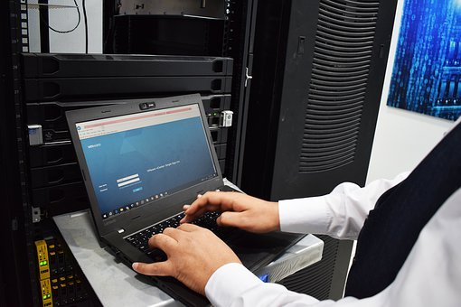 Man in white shirt working on computer in datacentre